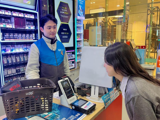 A model at a GS25 demonstrates a face-scanning payment system created by mobile financial firm Toss on Feb. 12. [GS25]