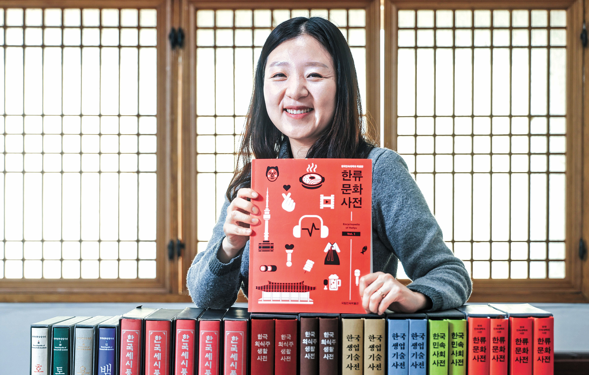 Baek Min-young, a senior curator at the National Folk Museum, holds up “Hallyu Cultural Encyclopedia,″ a two-volume encyclopedia on Hallyu [JOONGANG ILBO] 