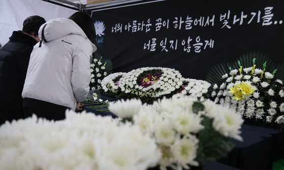 Visitors express their condolences on Feb.12 at a memorial altar at an elementary school in Daejeon where a 7-year-old girl was stabbed to death earlier this week. [NEWS1]