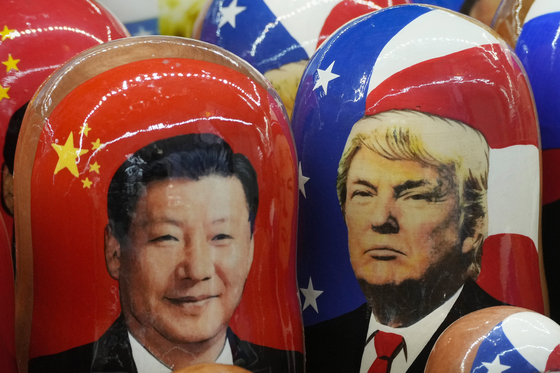 Traditional Russian wooden dolls called Matryoshka depicting China's President Xi Jinping, left, and U.S. President Donald Trump are on sale at a souvenir shop in St. Petersburg, Russia, on Nov. 21, 2024. [AP/YONHAP]