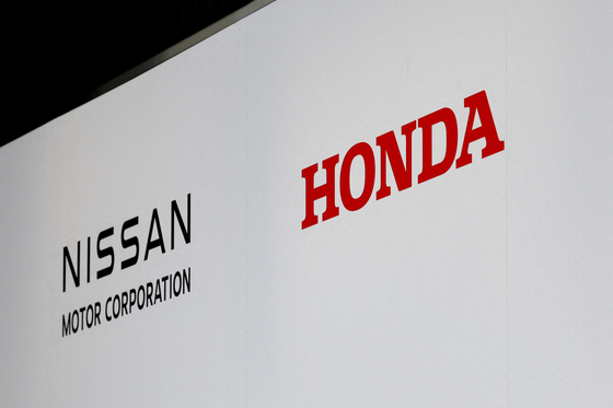 Logos of Nissan Motor Corporation and Honda are seen at a joint press conference on their merger talks, in Tokyo, Japan, December 23, 2024. [REUTERS]