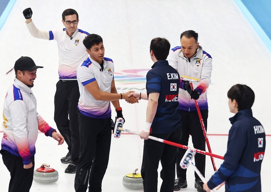 Kim Eun-bin from the national Korean men's curling team shakes hands with the Philippine national team after a 5-3 loss in the Asian Winter Games curling final in Harbin, China, on Friday, Feb. 14. [YONHAP]