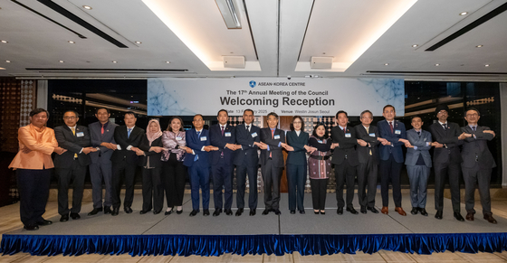 Kim Jae-shin, secretary general of the Asean-Korea Centre, stands in the middle of a group photo while holding hands with the organization's council directors at a dinner reception held at the Westin Josun Hotel in Jung District, central Seoul, on Feb. 13. Kang In-sun, second vice foreign minister of Korea, stands next to Kim, while Deputy Minister for Political Affairs Chung Byung-won stands fifth from right. [ASEAN-KOREA CENTRE]