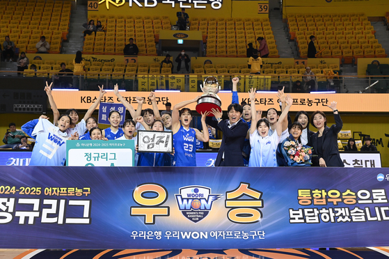 Asan Woori Bank Woori Won small forward Kim Dan-bi, center left, lifts the WKBL regular season trophy with head coach Wie Sung-woo at Cheongju Gymnasium in Cheongu, North Chungcheong on Feb. 16. [NEWS1] 