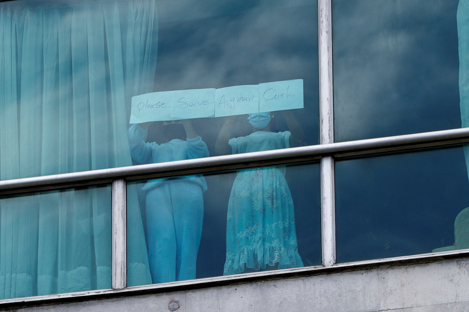 Women hold a sign at a hotel where migrants from Asia and the Middle East are housed after being deported to Panama as part of an agreement between the administration of U.S. President Donald Trump and the Central American nation, in Panama City, Panama, on Feb. 18. [REUTERS/YONHAP]