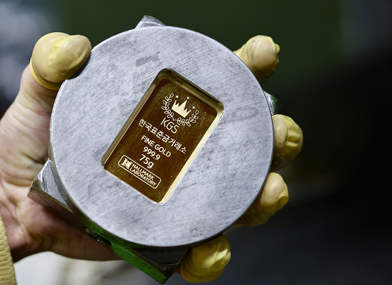 An employee holds a completed gold bar at a Korea Gold Standard factory in Jongno District, central Seoul, on Feb. 19. [YONHAP]