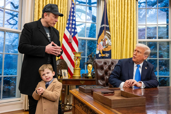 Tesla and SpaceX CEO Elon Musk with his son X Æ A-Xii join US President Donald Trump as he signs executive orders in the Oval Office of the White House in Washington, DC, on Feb. 11. [AFP/YONHAP]