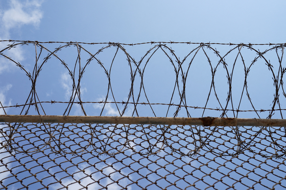 Barbed and razor wires are installed on the fence at The Port Isabel Detention Center, as seen during a media tour hosted by U.S. Immigration and Customs Enforcement Harlingen Enforcement and Removal Operations, in Los Fresnos, Texas, U.S., on June 10, 2024. [REUTERS/POOL/YONHAP]