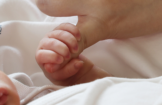 A newborn grips their mother's hand at a hospital in Suwon, Gyeonggi, on July 11, 2024. [YONHAP] 