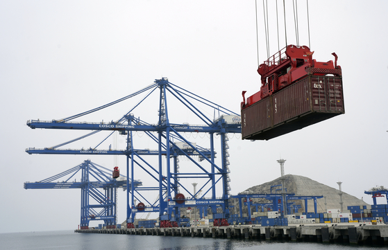 A container is lifted by a crane backdropped by the construction of the Chinese-funded port, in Chancay, Peru, on Oct. 29, 2024. [AP/YONHAP]