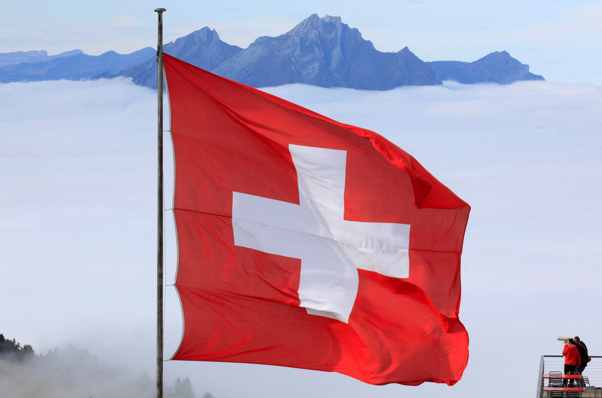 Mount Pilatus is seen behind the fog as Switzerland's national flag flies near the peak of Mount Rigi, Switzerland, on Oct. 22, 2019. [REUTERS/YONHAP]