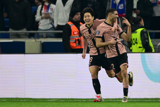 Paris Saint-Germain midfielder Lee Kang-in, left, celebrates with his teammate Achraf Hakimi during a Ligue 1 match against Lyon at Parc Olympique Lyonnais in France on Feb. 23. [AFP/YONHAP] 