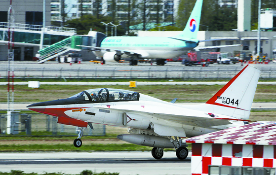 A military airplane lands at Gwangju Airport in April last year. A passenger airplane is seen behind the military aircraft. [YONHAP] 