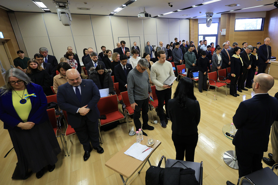 Attendees observe a moment of silence at the request of the ambassador of Ukraine to South Korea, Dmytro Ponomarenko, to honor those who have lost their lives in the war during a forum on the Russia-Ukraine war held at the Goethe-Institut in Yongsan District, central Seoul, on Monday. [YONHAP]