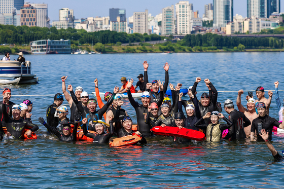 Seoul City Mayor Oh Se-hoon, middle, pose with the participants in the 2024 My Pace Triathlon Festival in the Han River around Songpa District, southern Seoul [NEWS1]
