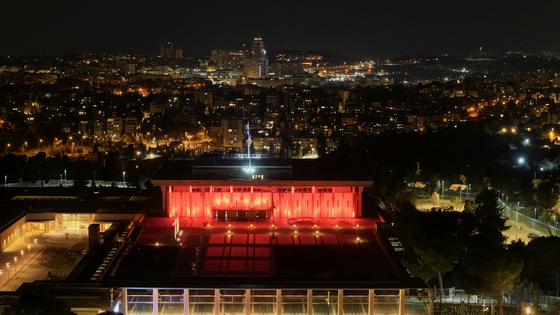 A drone view shows the Knesset, Israel's House of Representatives, as it is illuminated with orange light, one day ahead of the funeral of Shiri Bibas, 32, and her two children Ariel, 4, and Kfir, 9 months-old, who were kidnapped from their home in Kibbutz Nir Oz during the deadly Oct. 7, 2023 attack by Hamas and then killed in Gaza, in reference to the colour of their hair, in Jerusalem, Israel, on Feb. 25. [REUTERS]