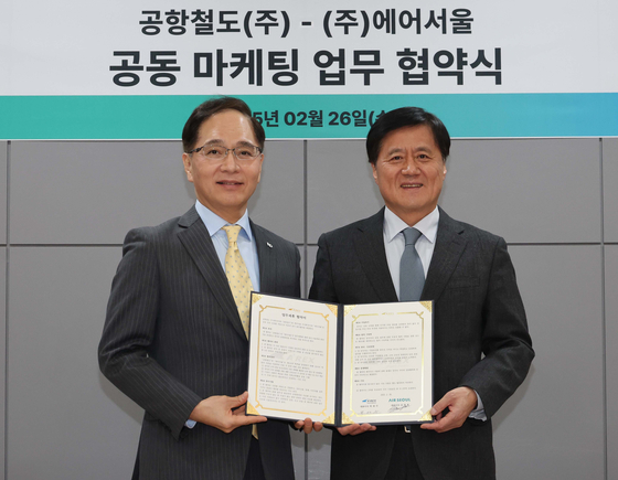 Air Seoul CEO Kim Joong-ho, left, and Airport Railroad President Park Dae-soo signed a memorandum of understanding to provide mutual discounts to customers and employees and conduct joint advertising at Seoul Station City Airport Terminal on Feb. 26. [YONHAP]