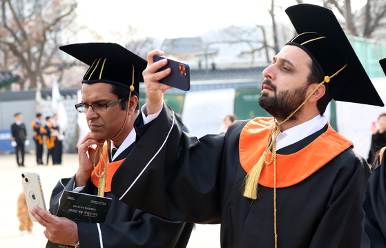 Students of Sungkyunkwan University take photos of each other at the school campus on Tuesday. [NEWS1]