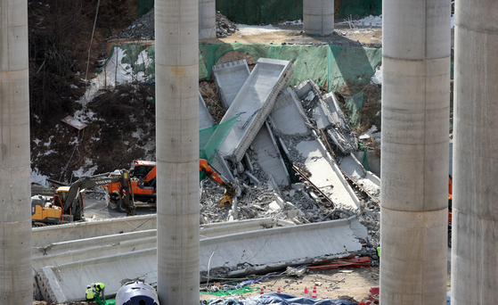 Firefighters try to rescue injured workers that were trapped under the rubble at the bridge construction site collapse in Anseong, Gyeonggi, on Feb. 25. [NEWS1]