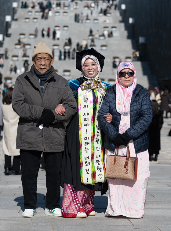 An international student from Ewha Womans University poses for a photo with her family on Monday, when the school's graduation ceremony took place. [NEWS1]