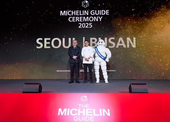 Chef Kang Min-goo, middle, poses with Managing Director of Michelin Korea Jerome Vincon after his restaurant Mingles in Seoul was awarded three stars during the Michelin Guide Seoul & Busan 2025 ceremony at The Westin Josun Seoul in Jung District, central Seoul, on Thursday. [MICHELIN GUIDE]