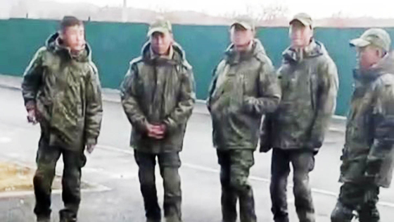 Men presumed to be North Korean soldiers stand outside a building in an unknown location in this photo released by Russian media outlet Astra last October. [SCREEN CAPTURE]