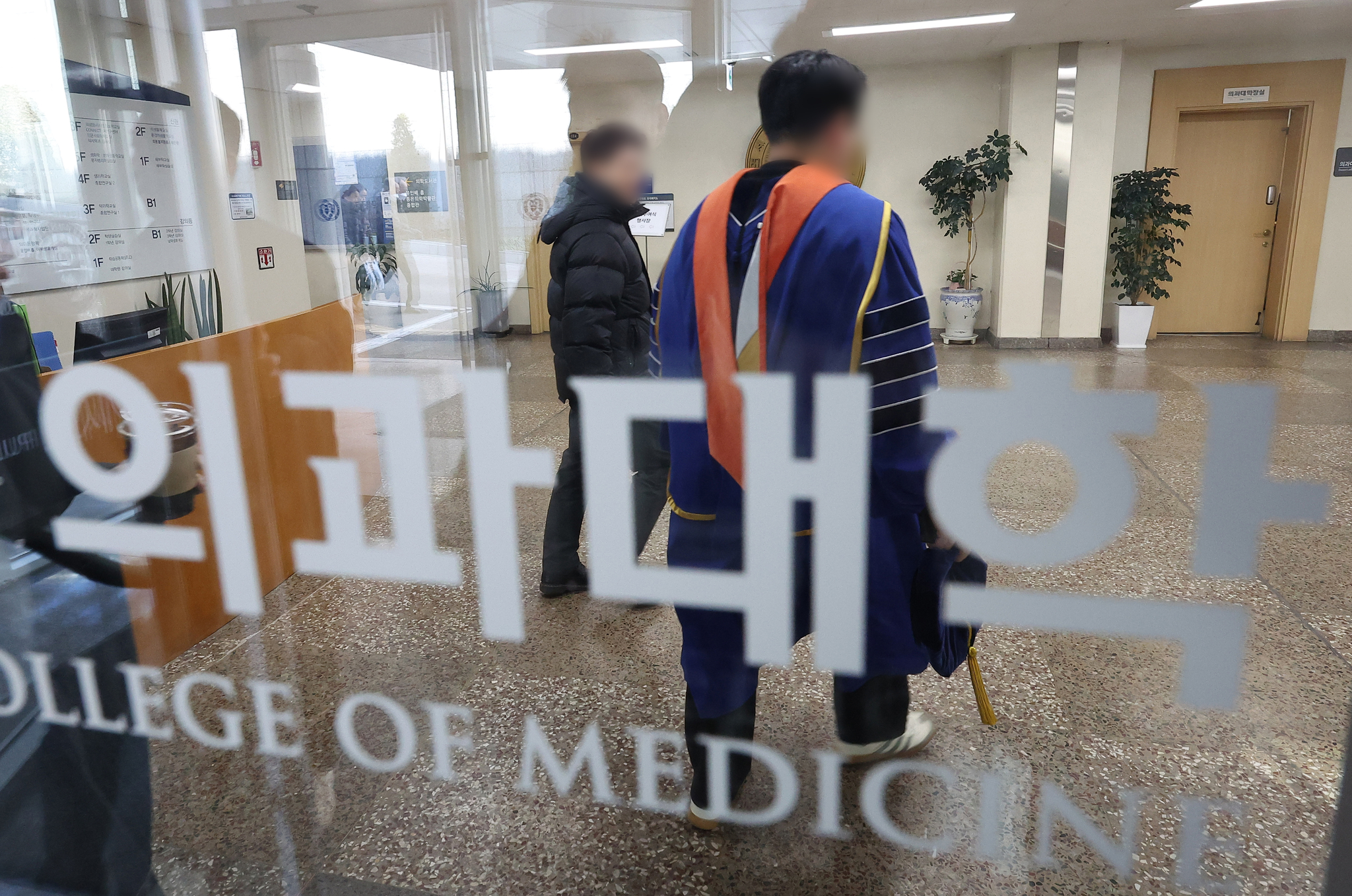 A student wearing a graduate gown is seen inside a medical school building in Seoul on Feb. 24. [YONHAP] 