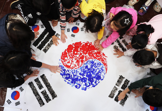 Children leave handprints to make a Taegeukgi, the Korean national flag, at an event at a bookstore in Suwon, Gyeonggi, on Feb. 27, ahead of the 106th anniversary of the March 1 Independence Movement which falls on a Saturday, starting a three-day weekend with Monday as a substitute holiday. The independence movement that started on the nation’s capital on March 1, 1919, with 33 Korean leaders’ Proclamation of Independence spread to other regions of the country as a demonstration against the Japanese occupation. [YONHAP]