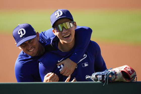 Los Angeles Dodgers catcher Austin Barnes, left, laughs with second baseman Kim Hye-seong during a spring training baseball practice on Feb. 26, 2025, in Phoenix, Arizona. [AP/YONHAP]