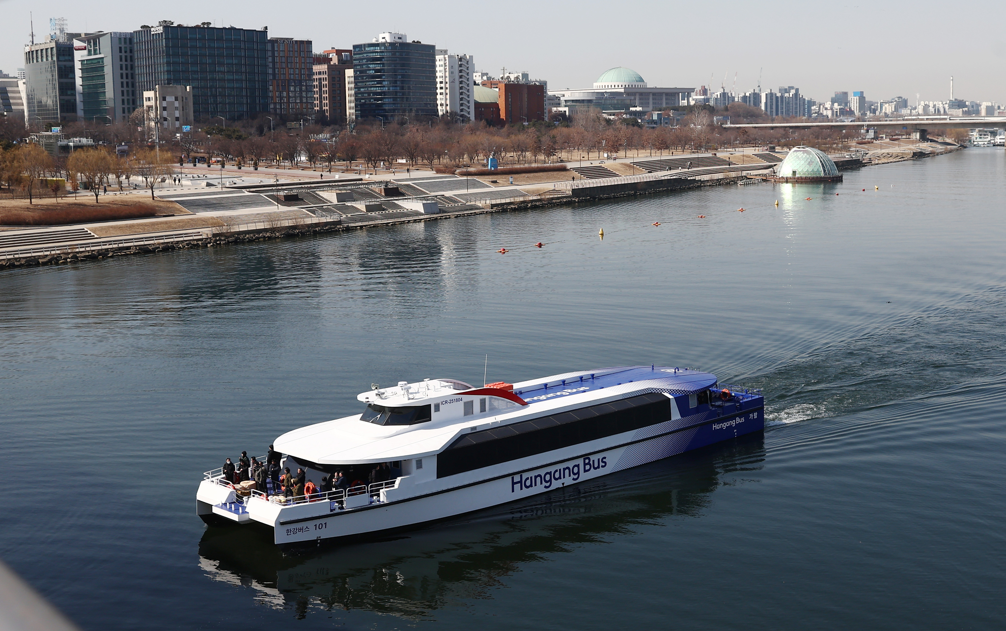 Hangang Bus 101, one of two public ferries purpose-built to carry people along the Han River, sails past Yeouido, western Seoul, on Feb. 27. [NEWS1]