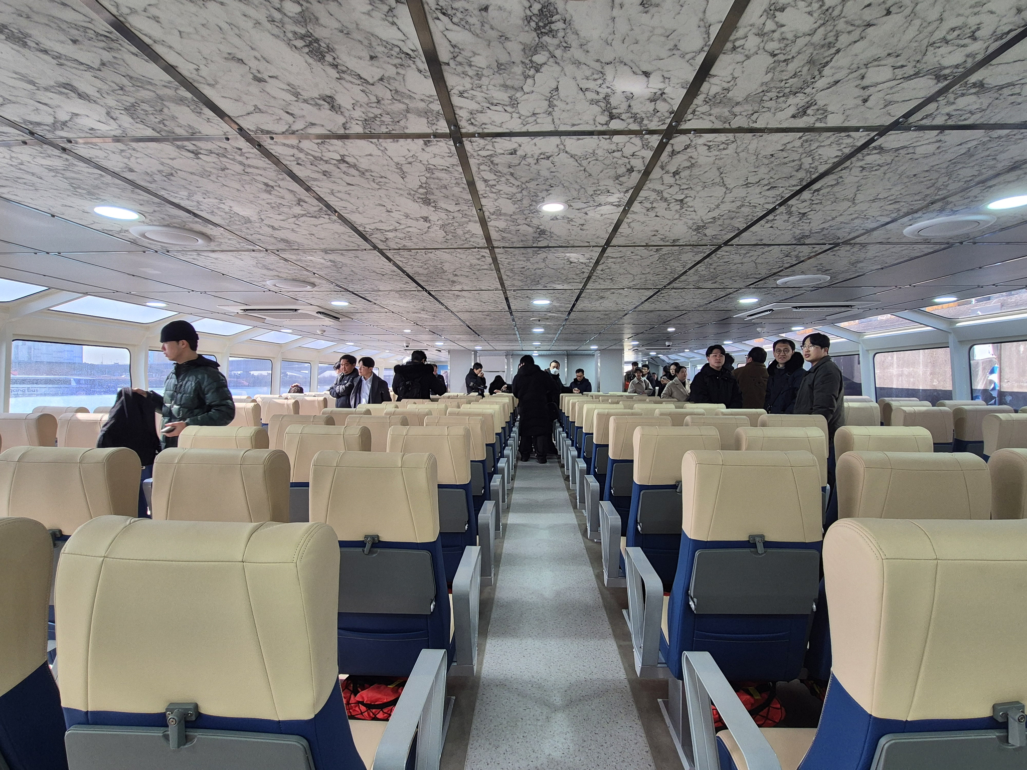 Reporters and Seoul city officials mingle inside one of the Hangang Bus ferries on Feb. 27. [JOONGANG ILBO] 