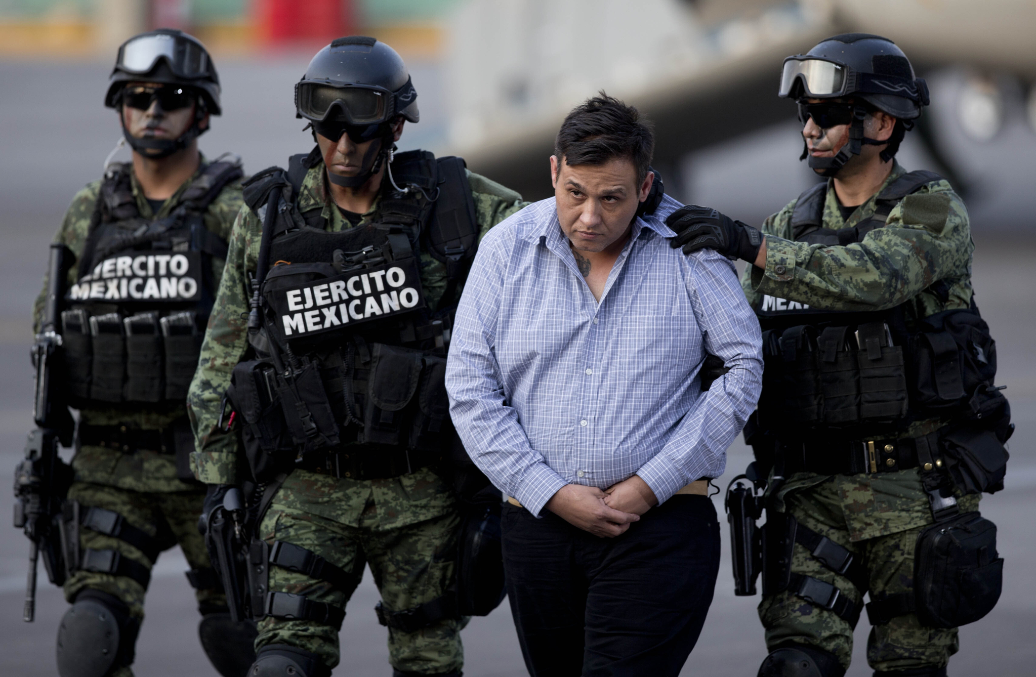 Soldiers escort a man who authorities identified as Omar Trevino Morales, alias ″Z-42,″ leader of the Zetas drug cartel, as he is moved from a military plane to a military vehicle at the Attorney General's Office hangar in Mexico City, on March 4, 2015. [AP/YONHAP]