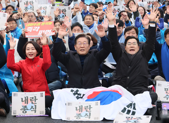 Kim Jae-yeon of the Progressive Party, left, liberal Democratic Party (DP) leader Lee Jae-myung, center, and DP floor leader Park Chan-dae raise their hands at a rally for the impeachment of President Yoon Suk Yeol in Jongno District, central Seoul on March. 1 [YONHAP]