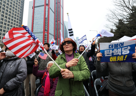 A protester at a rally against the impeachment of President Yoon Suk Yeol waves the Korean and U.S national flags in Yeouido, western Seoul, on March. 1. [NEWS1]