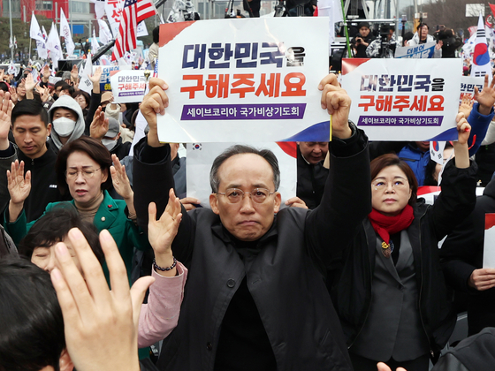 Conservative People Power Party (PPP) Rep. Choo Kyung-ho, left, holds up a placard that says ″Please Save Korea″ at a rally in Yeouido, western Seoul, on March 1. [NEWS1]