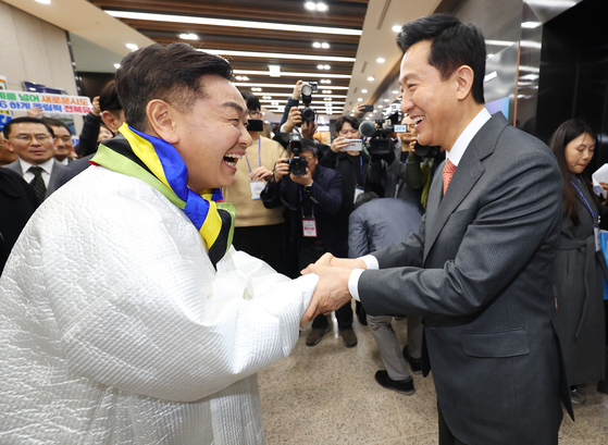 North Jeolla Gov. Kim Kwan-young, left, and Seoul Mayor Oh Se-hoon shake hands after presenting their cases ahead of the Korean Sport & Olympic Committee's vote on Korea's candidate to bid for the 2036 Olympics at Olympic Parktel in Jamsil, southern Seoul, on Feb. 28. [YONHAP] 
