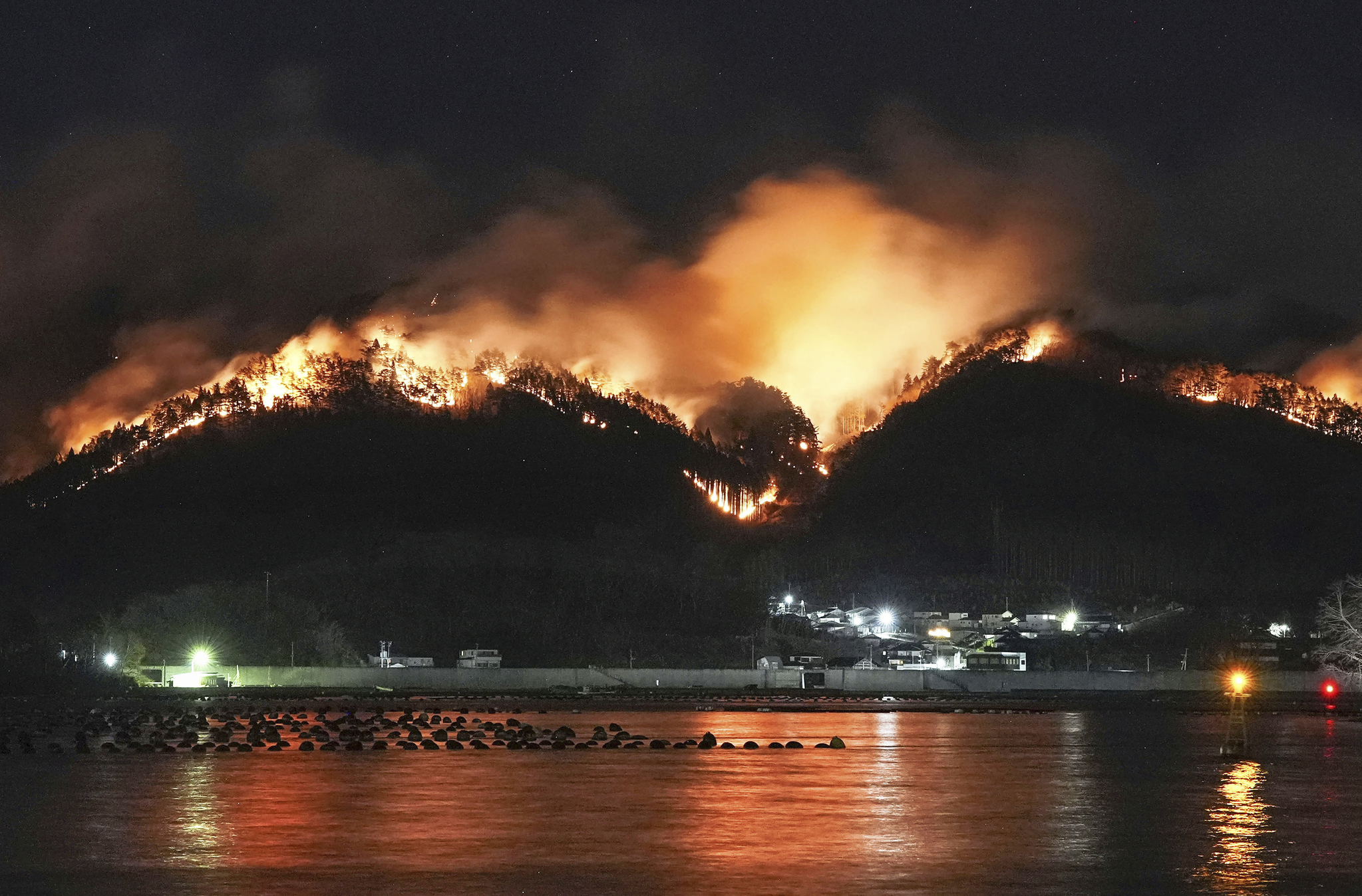 A forest fire, which started last Wednesday, continues to spread behind houses in Ofunato, Iwate prefecture, northern Japan, on March 3. [KYODO NEWS/AP/YONHAP] 