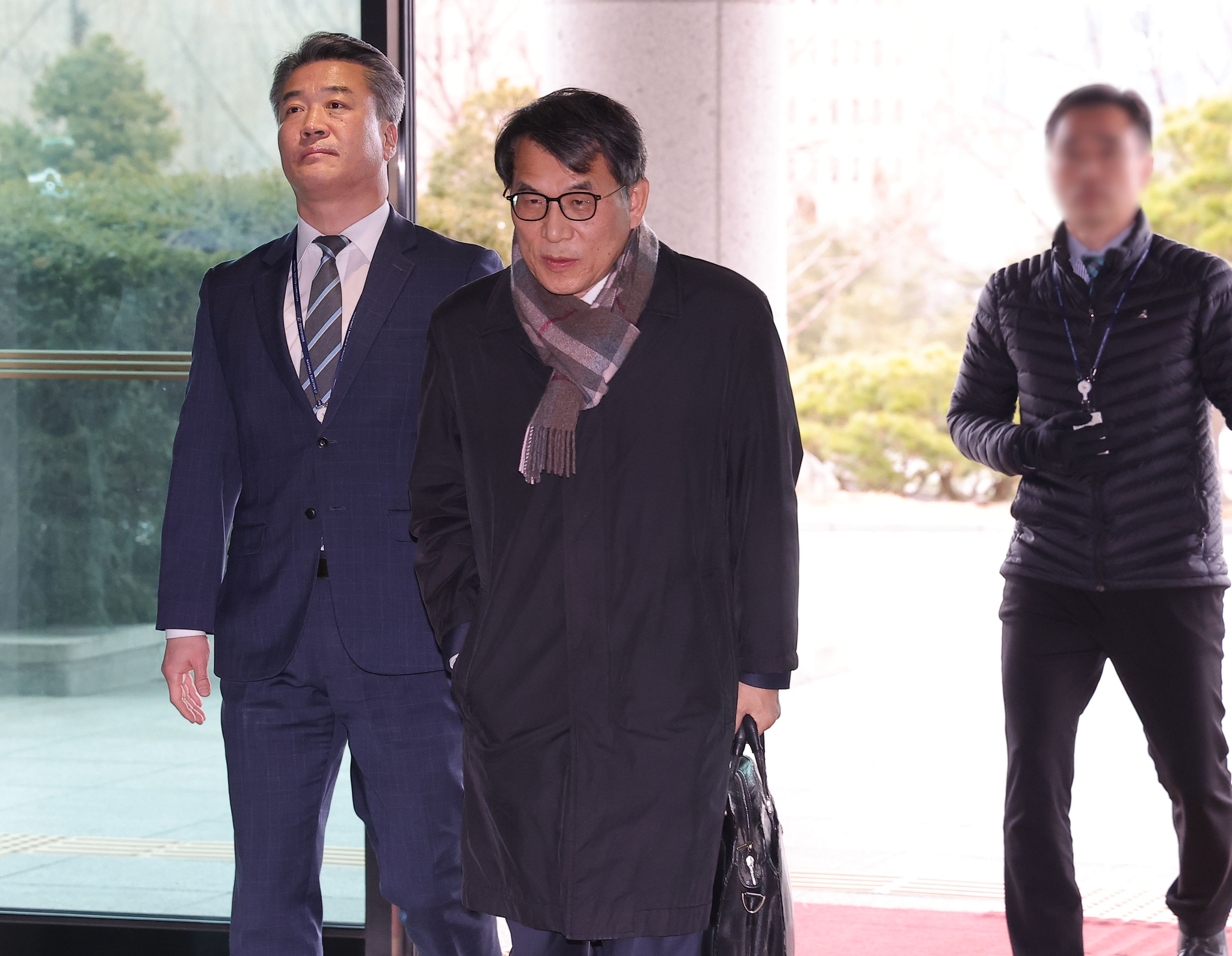 Rho Tae-ak, a commissioner of the National Election Commission (NEC), center, walks inside NEC headquarters in Gwacheon, Gyeonggi on March 5. [YONHAP] 