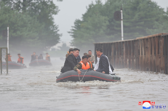 North Korean leader Kim Jong-un, left, inspects flooded areas in the northwestern city of Sinuiju following heavy rainfall in a photo carried by the state-run Korean Central News Agency in August 2024. [YONHAP]