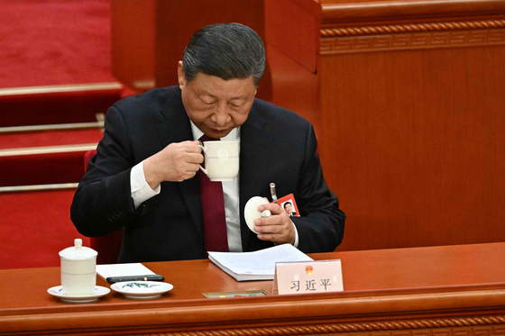 China's President Xi Jinping drinks tea during the opening session of the National People's Congress (NPC) at the Great Hall of the People in Beijing on March 5. [AFP/YONHAP] 