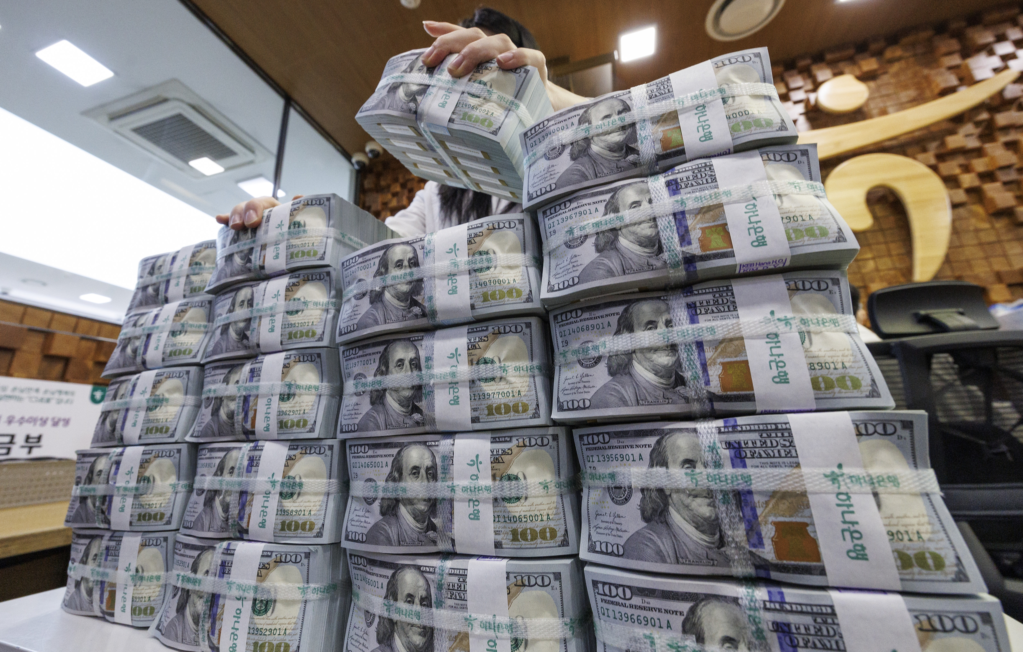 An official checks dollar notes at Hana Bank's Counterfeit Notes Response Center in Seoul on Feb. 5. [YONHAP]