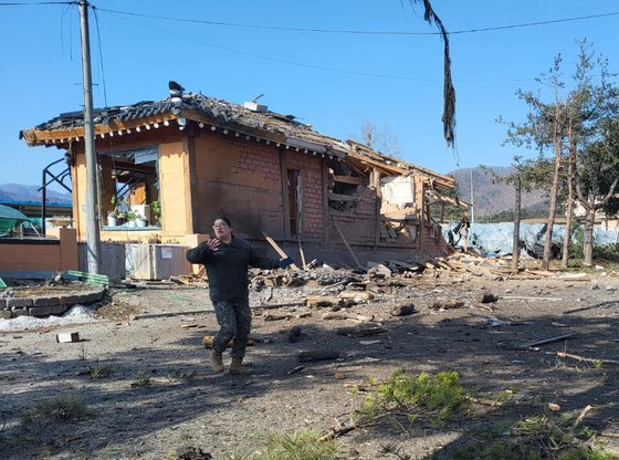 A person in military uniform is seen at a severely damaged home after eight bombs fell over Pocheon, Gyeonggi, during a Korean Air Force live-fire exercise on March 6. [YONHAP]