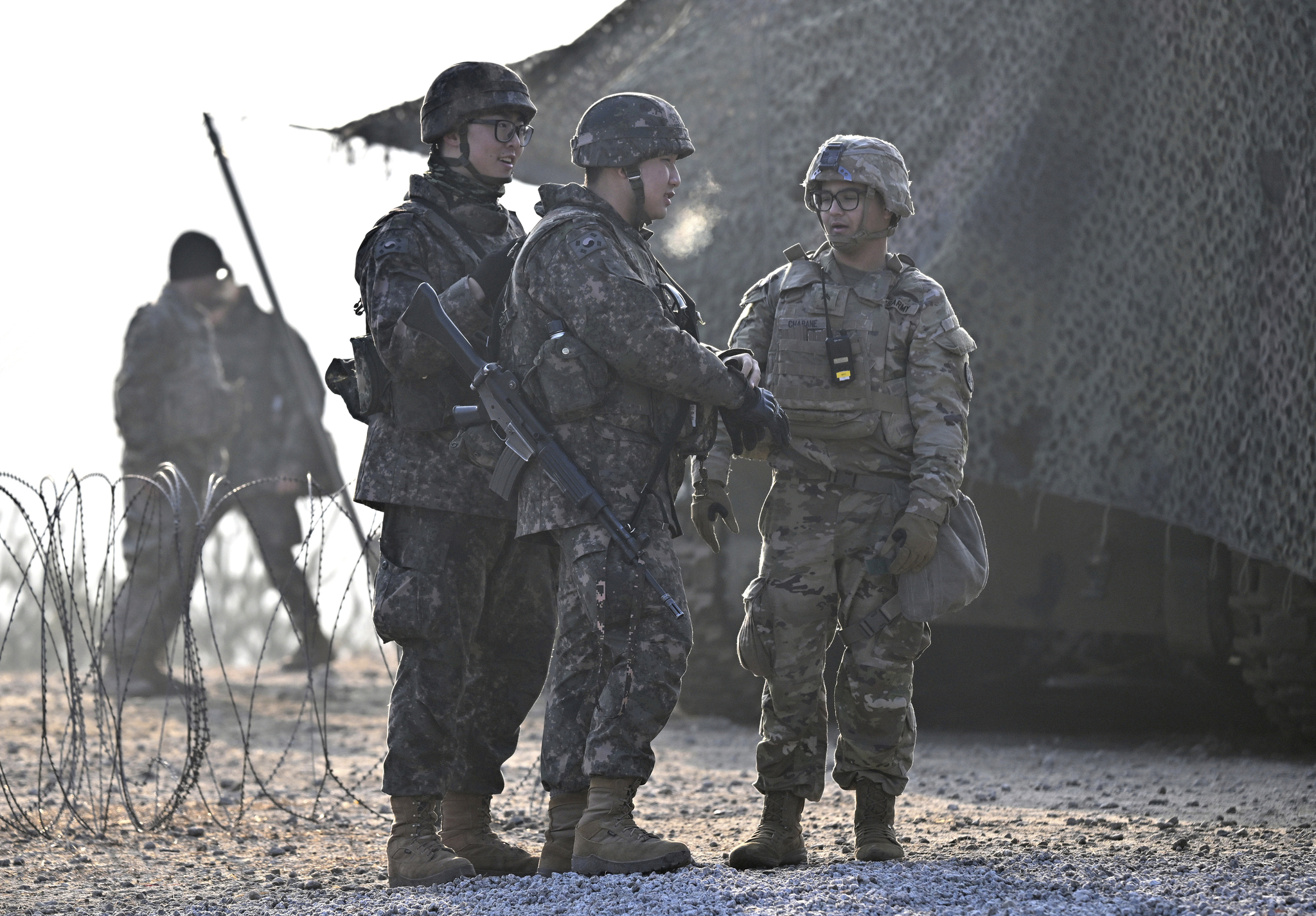 South Korean soldiers talk with a U.S. soldier, right, during their joint live fire exercise at a military training field in Pocheon, on March 14, 2024 as part of the annual Freedom Shield joint military exercise between South Korea and the United States. [AP/YONHAP]
