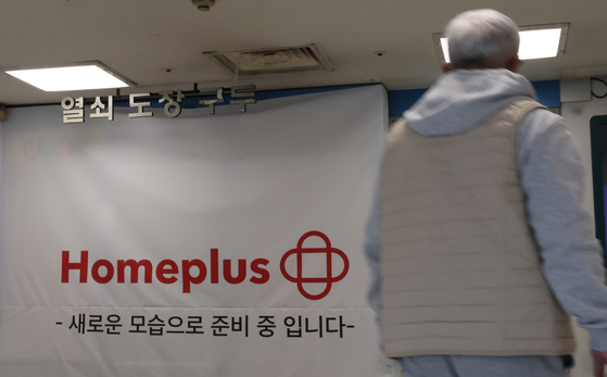 A passerby walks by a Homeplus store in Seoul on March 6. [YONHAP]