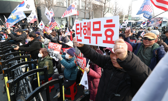 Protesters against President Yoon Suk Yeol's impeachment hold their pickets up high at the presidential residence at Yongsan District, central Seoul, on March 7 as they hear the news of Yoon's arrest being overturned by the court. [NEWS1]