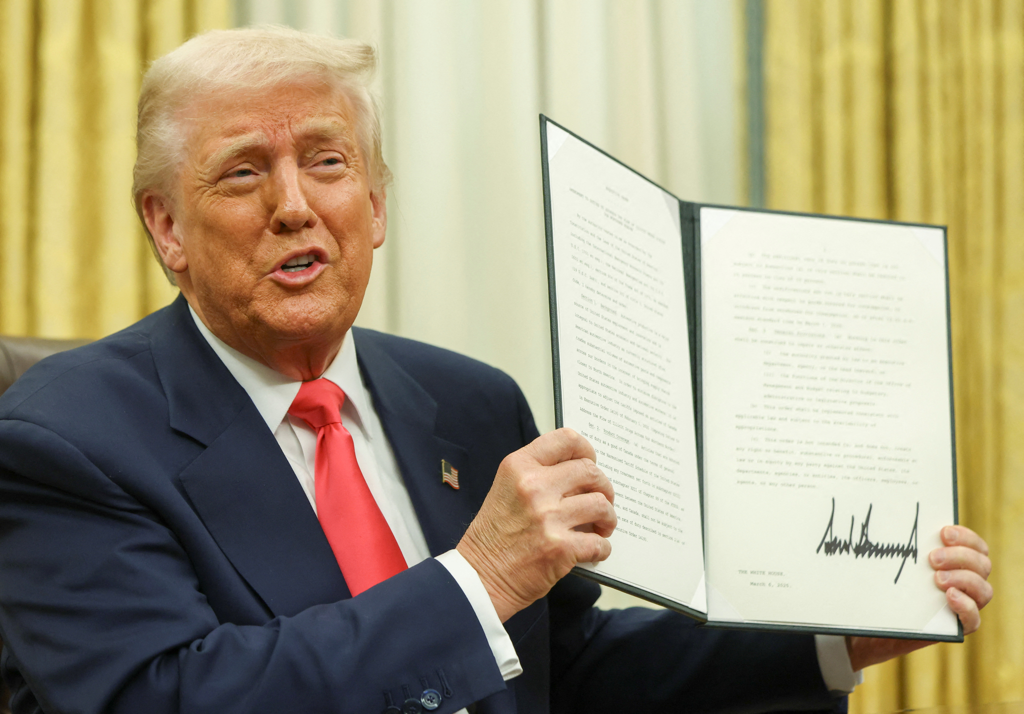 U.S. President Donald Trump holds an executive order in the Oval Office, at the White House in Washington, D.C., U.S. on March 6. [REUTERS/YONHAP]