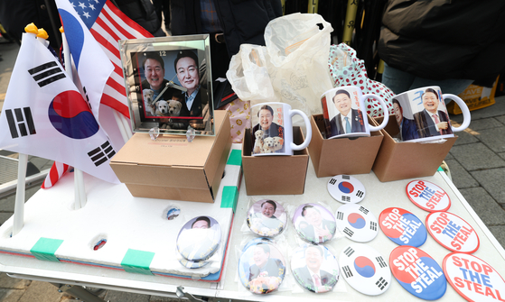Clocks and mugs with pictures of President Yoon Suk Yeol and his dogs are on display in front of the presidential residence at Yongsan District, central Seoul, on March 7. [NEWS1]