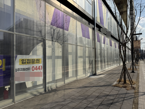 A vacant shopping center in Eojin-dong, Sejong, pictured on March 6, is shuttered down. A sign directing potential business owners interested in renting space is hung up in the window. [IM SOUNG-BIN]