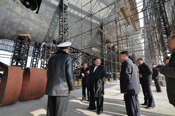 North Korean leader Kim Jong-un, center, visits a major shipyard to inspect the progress in building a nuclear-powered submarine in a photo carried by North Korea's official Rodong Sinmun on March 8. [YONHAP]