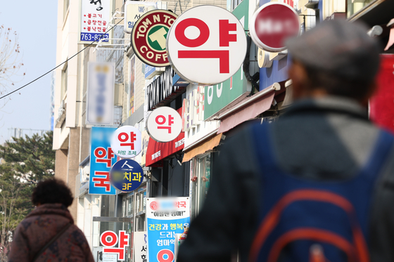 Pedestrians walk past a row of pharmacies in Jongno District, central Seoul, on March 9. [YONHAP]